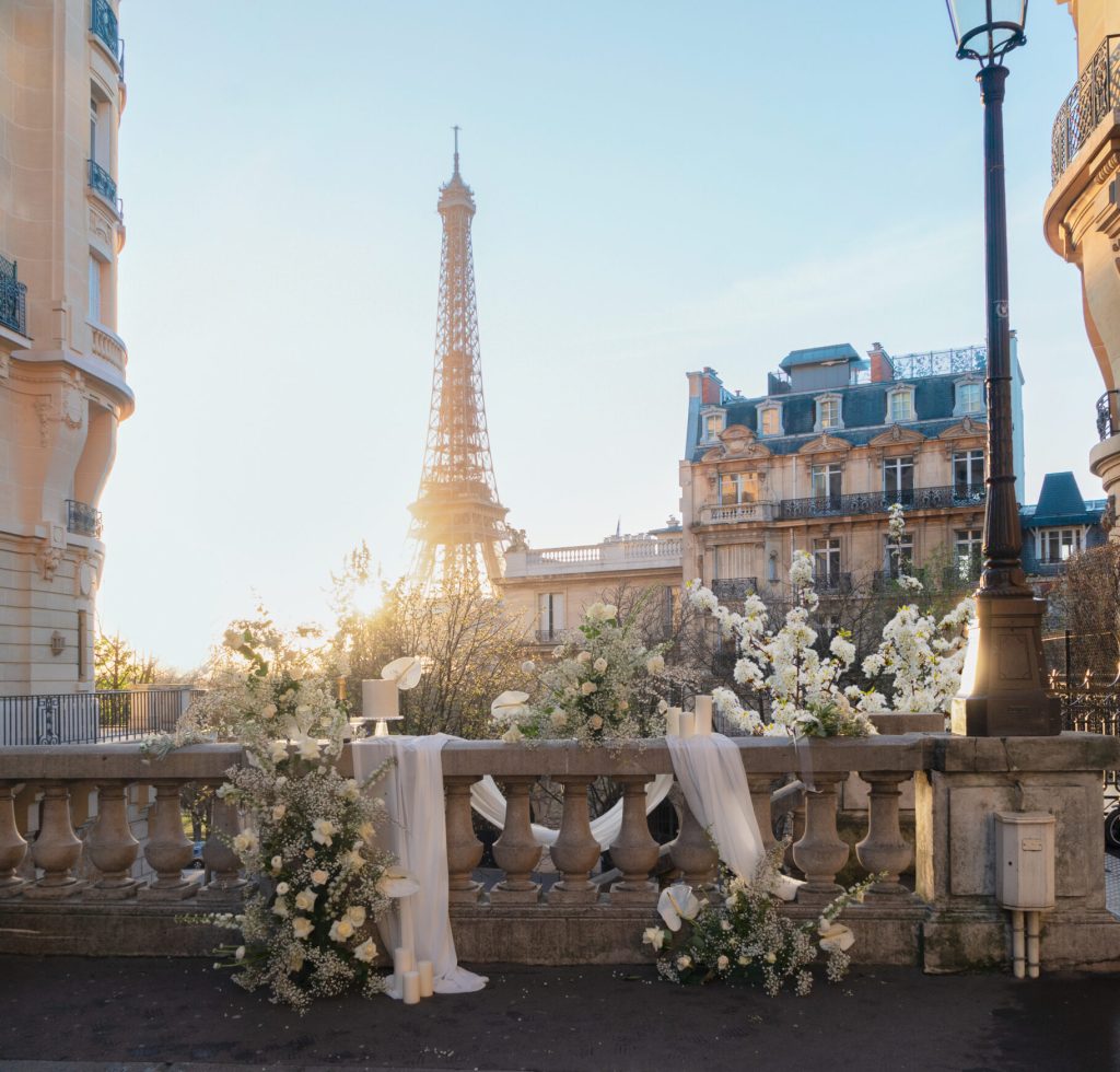 cosy Paris street with view on the famous Eiffel Tower on spring day with white flowers decorations, Paris France